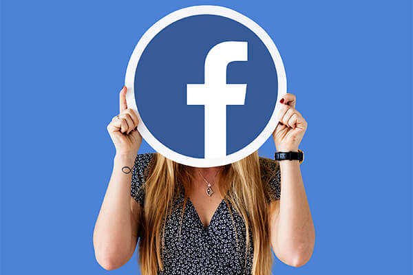 Mulher esconde rosto atrás de ícone do Facebook